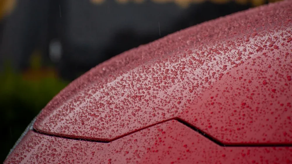  Car surface coated with superhydrophobic coating, droplets beading up, showcasing its excellent water and stain repelling capabilities